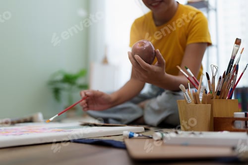 Preview: Joyful young female artist painting on canvas at workshop