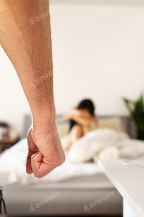 Preview: Portrait of a frightened to death Asian woman sitting on bed