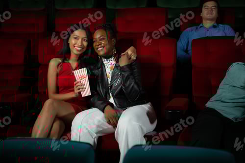 Preview: Both of young woman watching movie in cinema, sitting on red seats