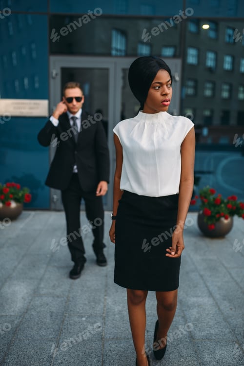 Preview: Business woman, bodyguard in suit on background