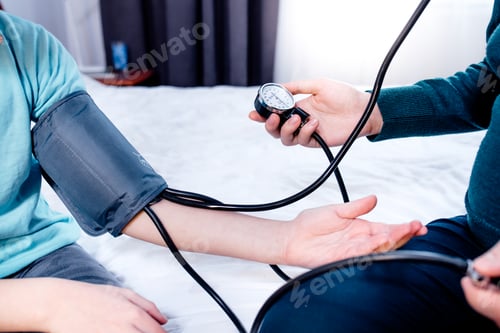 Preview: Female measuring blood pressure of a child using the pressure sleeve and her stethoscope