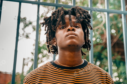 Preview: Portrait of young handsome stylish black man with natural hair afro dreadlocks. Afroamerican guy. St