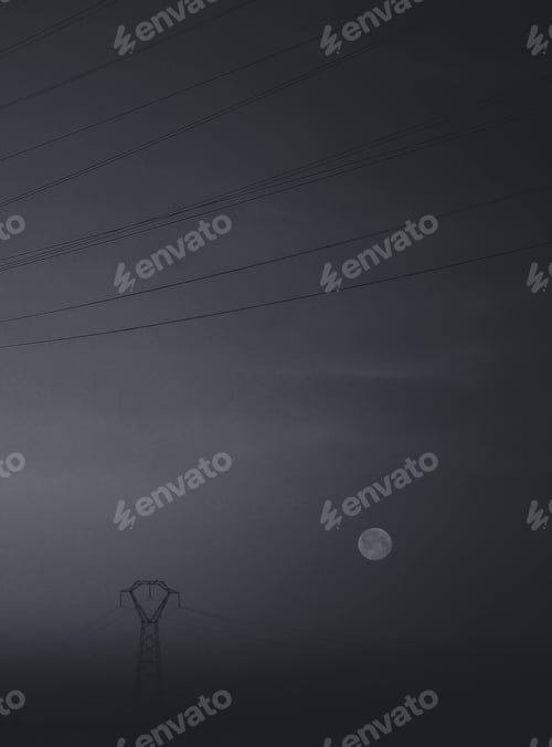 Preview: Vertical shot of a high voltage transmission tower and the moon at night