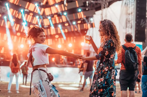 Preview: Two beautiful friends drinking beer and having fun on a music festival