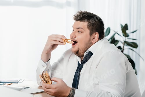 Preview: overweight businessman eating hamburger and french fries at workplace