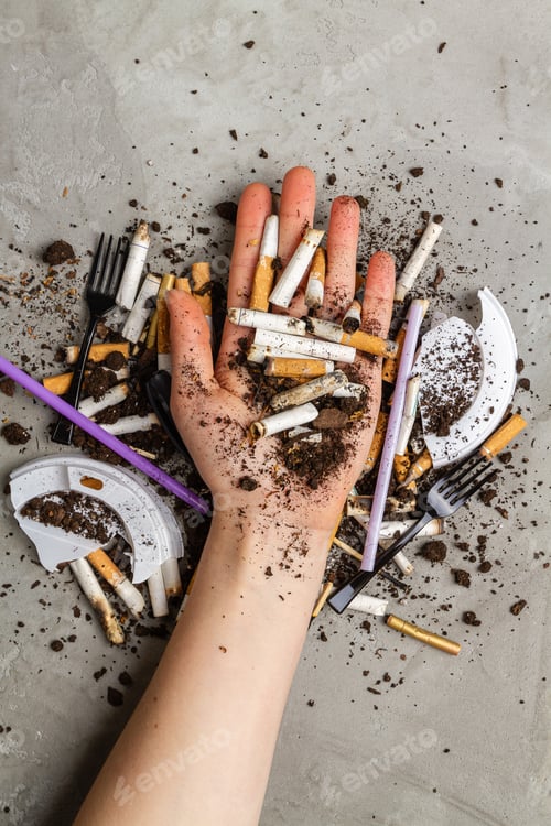 Preview: Hand holding pile of cigarettes with dirt.