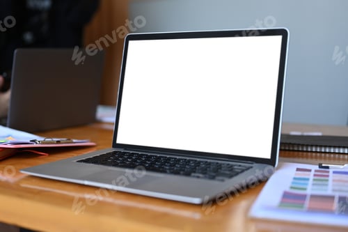 Preview: Computer laptop and paperwork on wooden table in office.