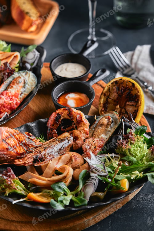 Preview: Assorted seafood on plates. Beautiful composition on a served seafood table, squid, shrimp, salmon