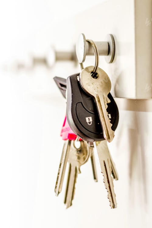 Preview: Selective focus vertical shot of a bunch of keys hanging on a key holder with a blurred background