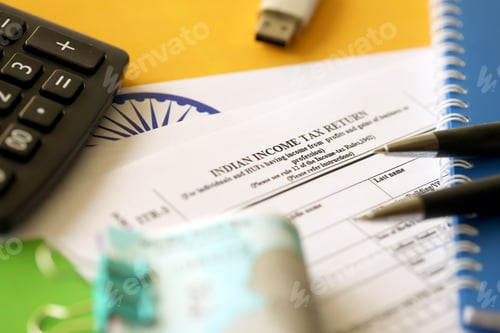 Preview: Indian income tax return blank form with pen and indian rupees bills