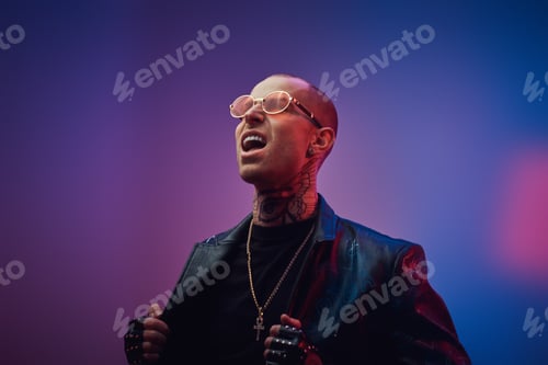Preview: Fashionable tattooed male model posing in a studio