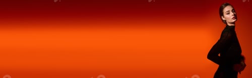 Preview: Elegant young woman posing gracefully against a vibrant orange backdrop in a chic outfit