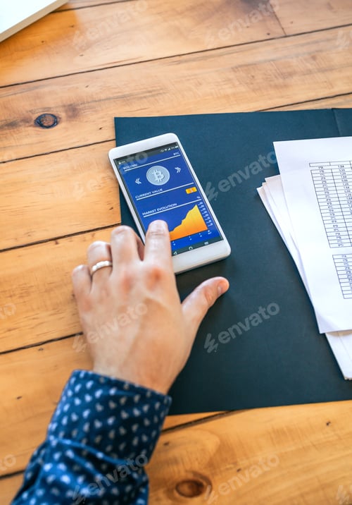 Preview: Businessman hand touching mobile screen with bitcoins