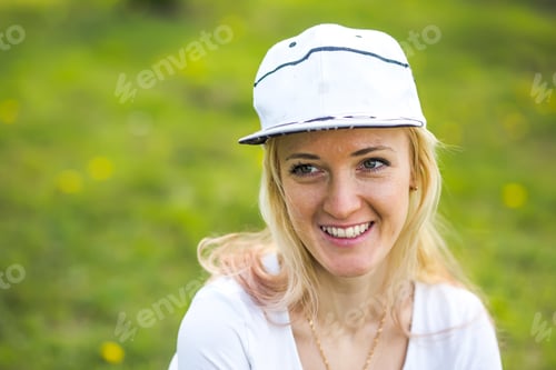 Preview: Portrait of a beautiful young woman in a white baseball cap
