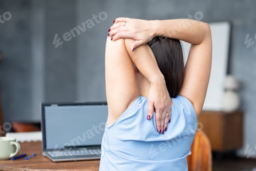 Preview: woman stretches her body after hard worling day. Rear view