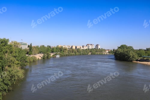 Preview: Tranquil river view in Tiraspol, Prednestrovie with clear skies and lush greenery