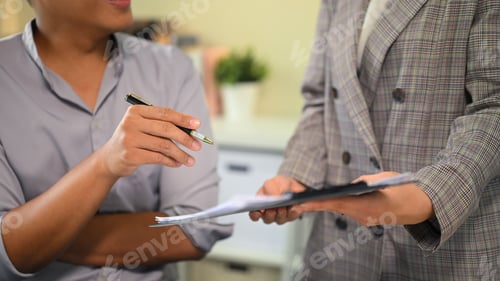 Preview: Office workers collaborating on project, sharing ideas and reviewing reports together