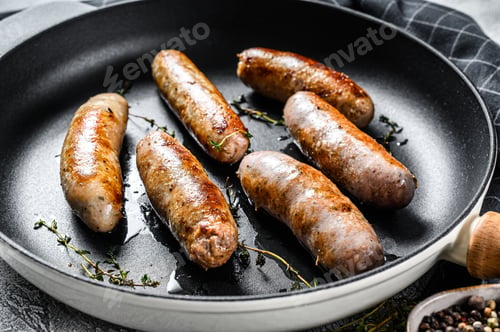 Preview: Grilled assorted pork, beef and chicken sausages with spices in a pan. Gray background. Top view