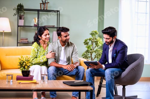 Preview: Indian family investment consultation at home with professional agent reviewing paperwork