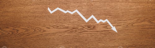 Preview: top view of white paper cut recession arrow on wooden desk, panoramic shot