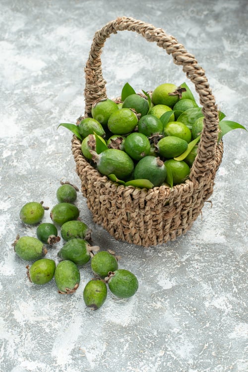 Preview: top view fresh feijoas in wicker basket on grey isolated background