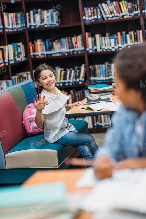 Preview: beautiful multiethnic schoolgirls greeting at school library