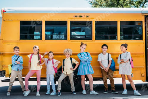 Preview: group of adorable schoolchildren posing in front of school bus