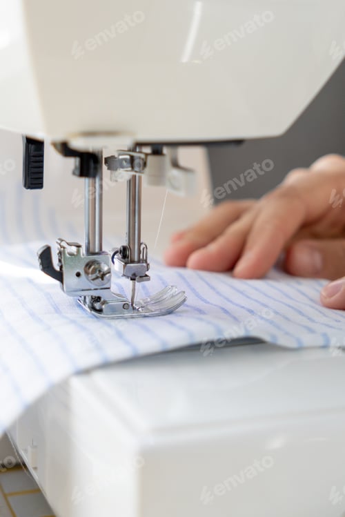 Preview: woman sews a light fabric on a sewing machine. making clothes, hobbies.