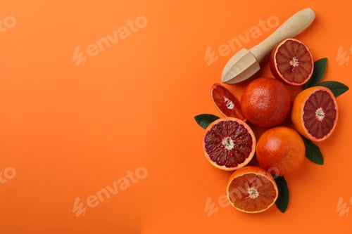Preview: Red oranges, leaves and juicer on orange background