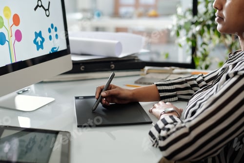 Preview: Hand of young African American graphic designer with stylus and touchpad