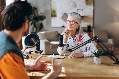 Preview: Radio host interviewing mature woman with pink ribbon about breast cancer awareness