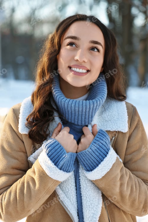 Preview: Portrait of smiling woman in winter snowy park