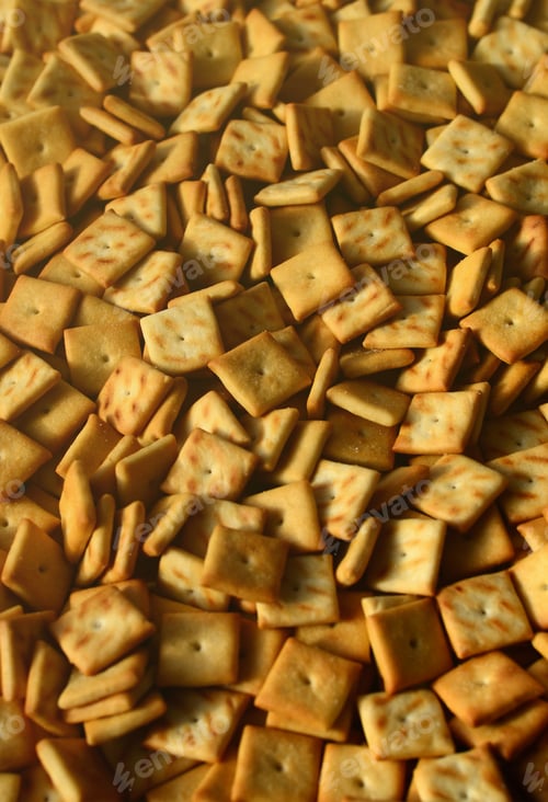 Preview: A lot of small cookies are square shaped. A pattern of a yellow salt cracker.