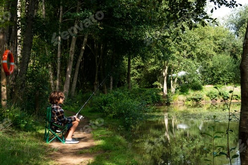 Preview: Boy fishing by lakeside, Bournemouth, UK
