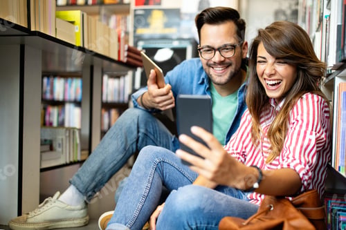 Preview: Group of happy students reading books and preparing to exam in library
