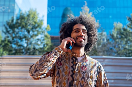 Preview: Afro man talking on the phone outdoors.