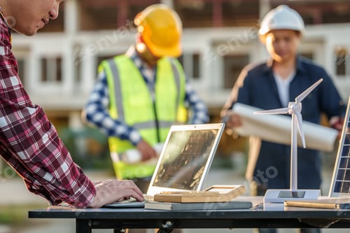 Preview: engineers discussing a solar energy project with a small solar panel model on the table, a laptop
