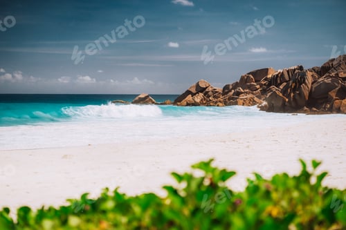 Preview: Ocean foamy waves and white sand beach at Petite Anse, La Digue in Seychelles