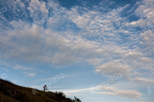 Preview: Silhouette of a cross country cyclist going downhill
