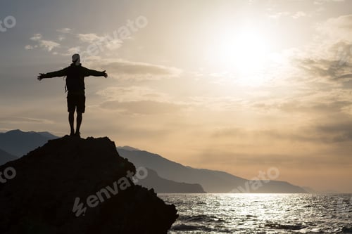 Preview: Man with arms outstretched celebrate mountains sunrise