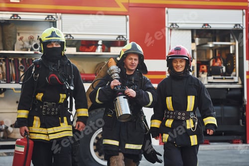 Preview: Group of firefighters in protective uniform that outdoors near truck
