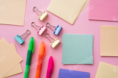 Preview: top view of fold back clips near paper notes and colorful pens on pink