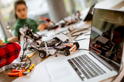 Preview: Happy kids programming electric toys and robots at robotics classroom