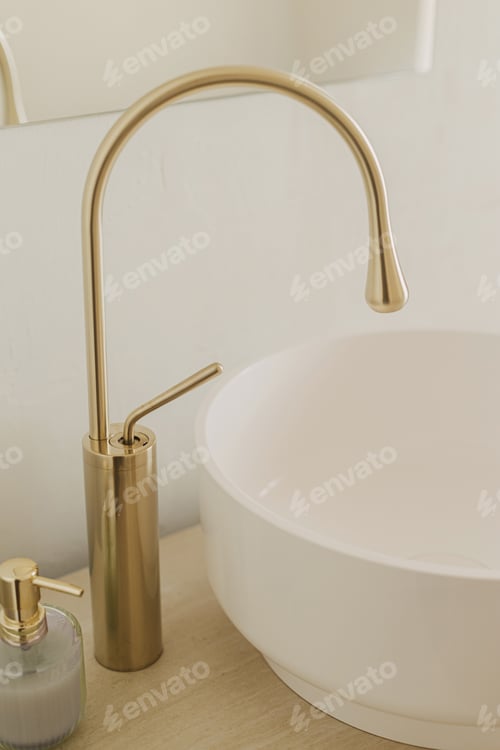 Preview: Modern ceramic sink with golden faucet on rustic stand with soap and towel