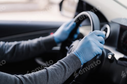 Preview: Driver wears rubber protective gloves protects from coronavirus drives car during epidemic
