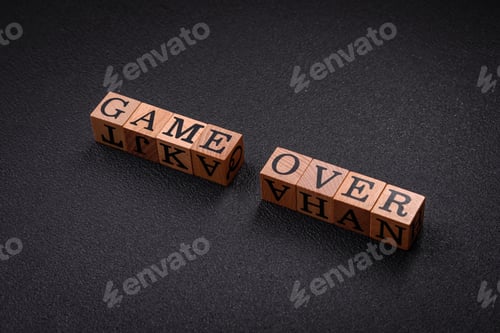 Preview: The inscription game over on wooden cubes on a dark concrete background
