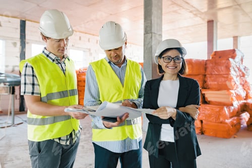 Preview: Team of builders engineers at construction site, reading blueprint.