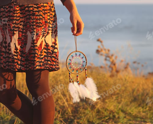 Preview: Brunette woman with long hair holding dream catcher
