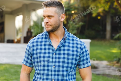 Preview: Smiling caucasian man outside house looking away from camera in garden