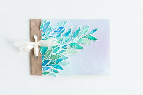 Preview: top view of watercolor invitation with leaves and ribbon isolated on white, wedding invitation